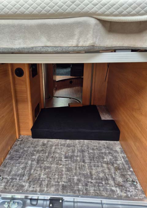 De bagageruimte onder het bed van de Pössl RoadcampR kan dienst doen als aangenaam verblijf voor een hond