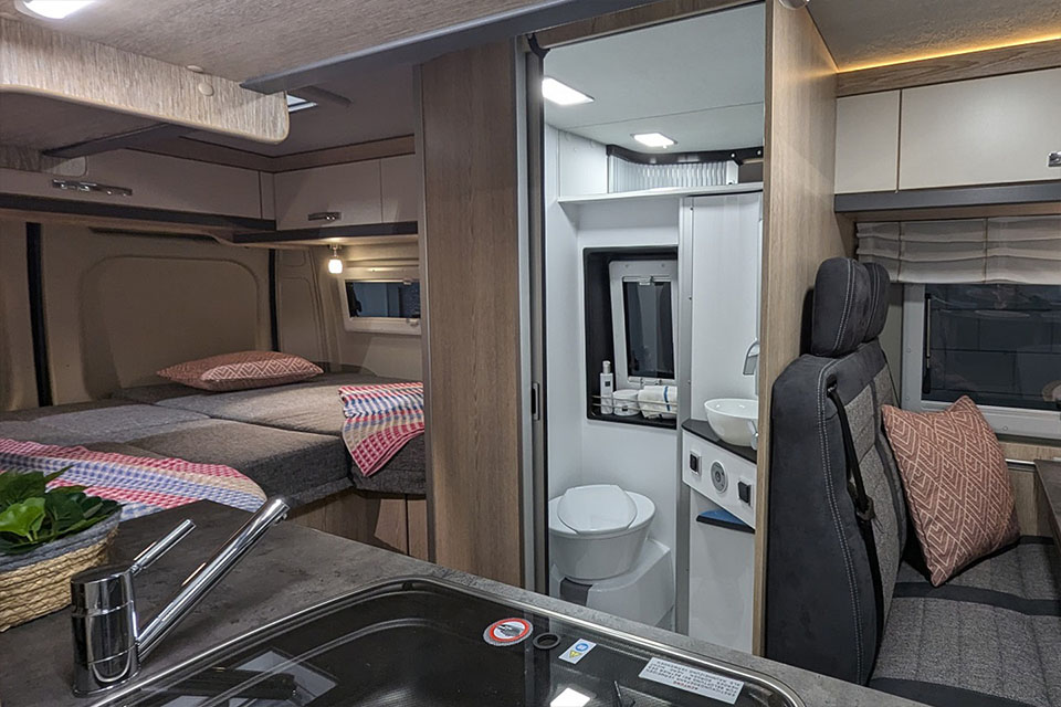 Luxe buscamper huren met een badkamer met praktische zwenkdouche.